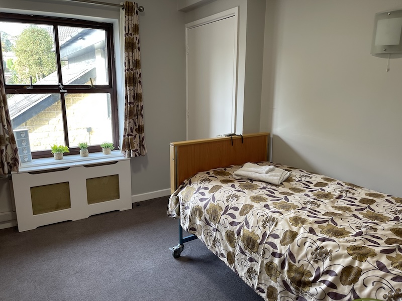bed facing the window with plant pots on the window sill